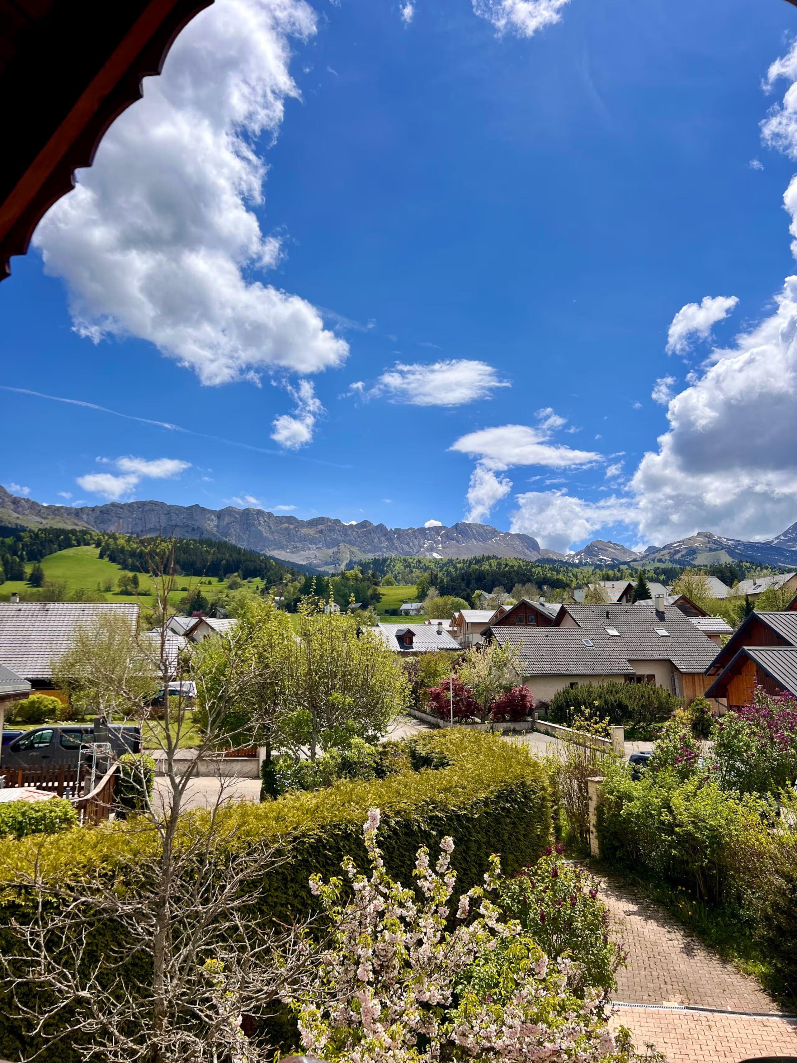 Un quartier résidentiel avec des maisons, un ciel dégagé et des montagnes en arrière-plan.