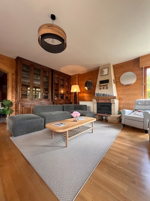 A living room with a fireplace, bookshelves, a sofa, and a coffee table.