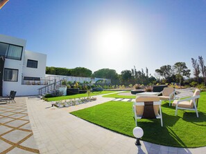 Eine moderne Außenpatio mit Pool, Sitzgelegenheiten im Freien und einer Treppe zu einer erhöhten Ebene.