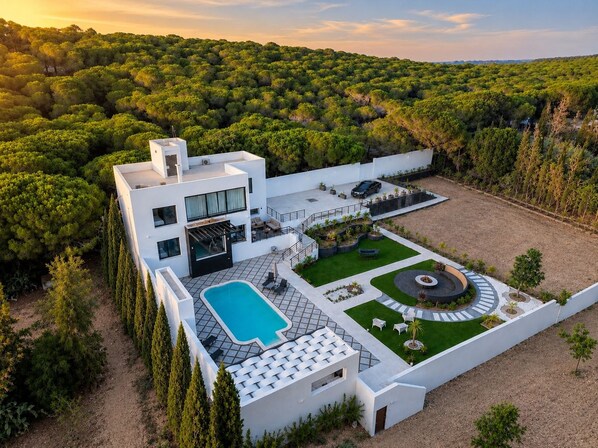 Una casa moderna con piscina, patio y jardín.