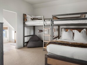 A bunk bed room with a desk and chair, a grey bean bag, and a framed picture on the wall. - Saddle Ridge S2 3 Bedroom Home (Big Sky)