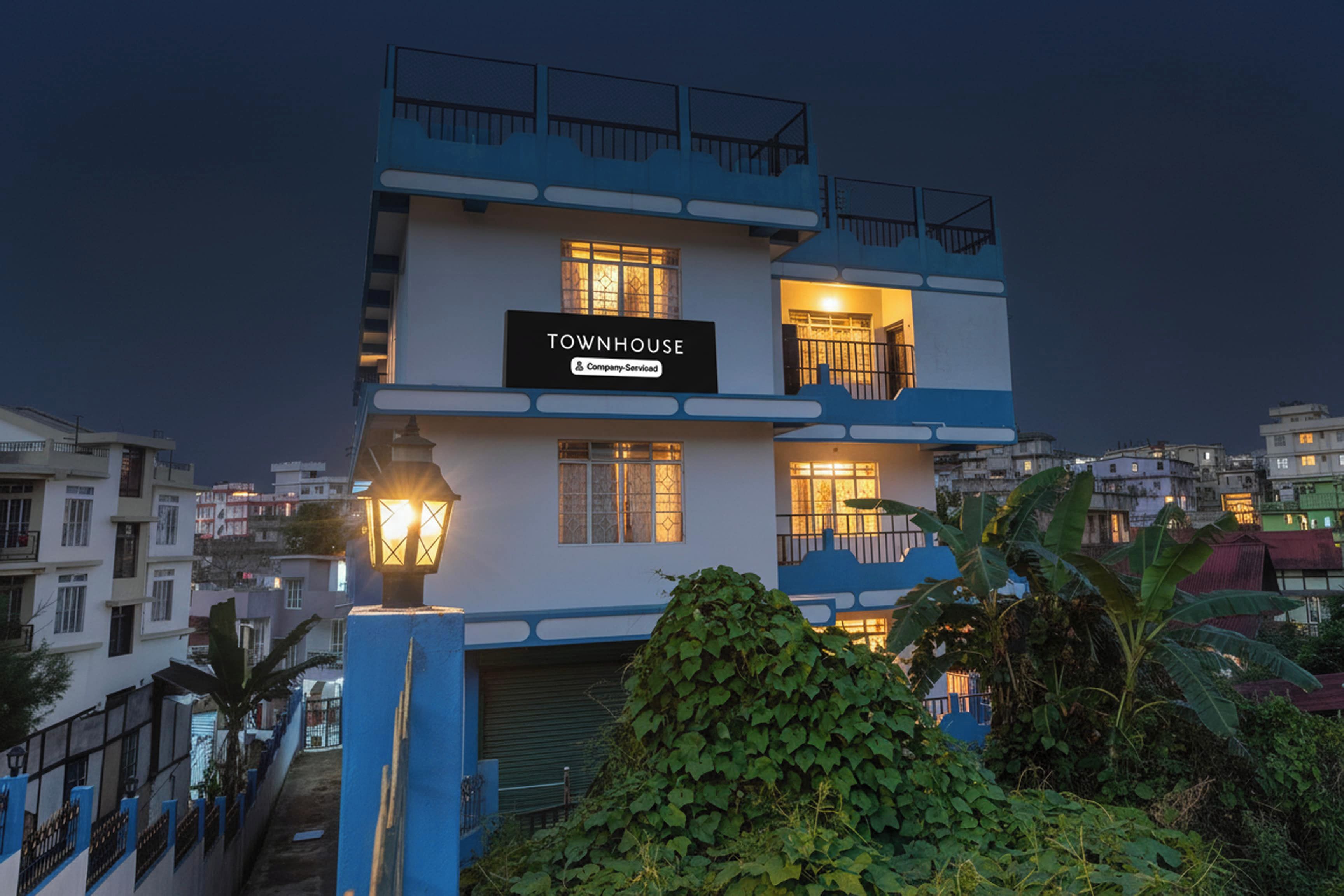 Un edificio de varios pisos con un letrero que dice 'TOWNHOUSE' y balcones.
