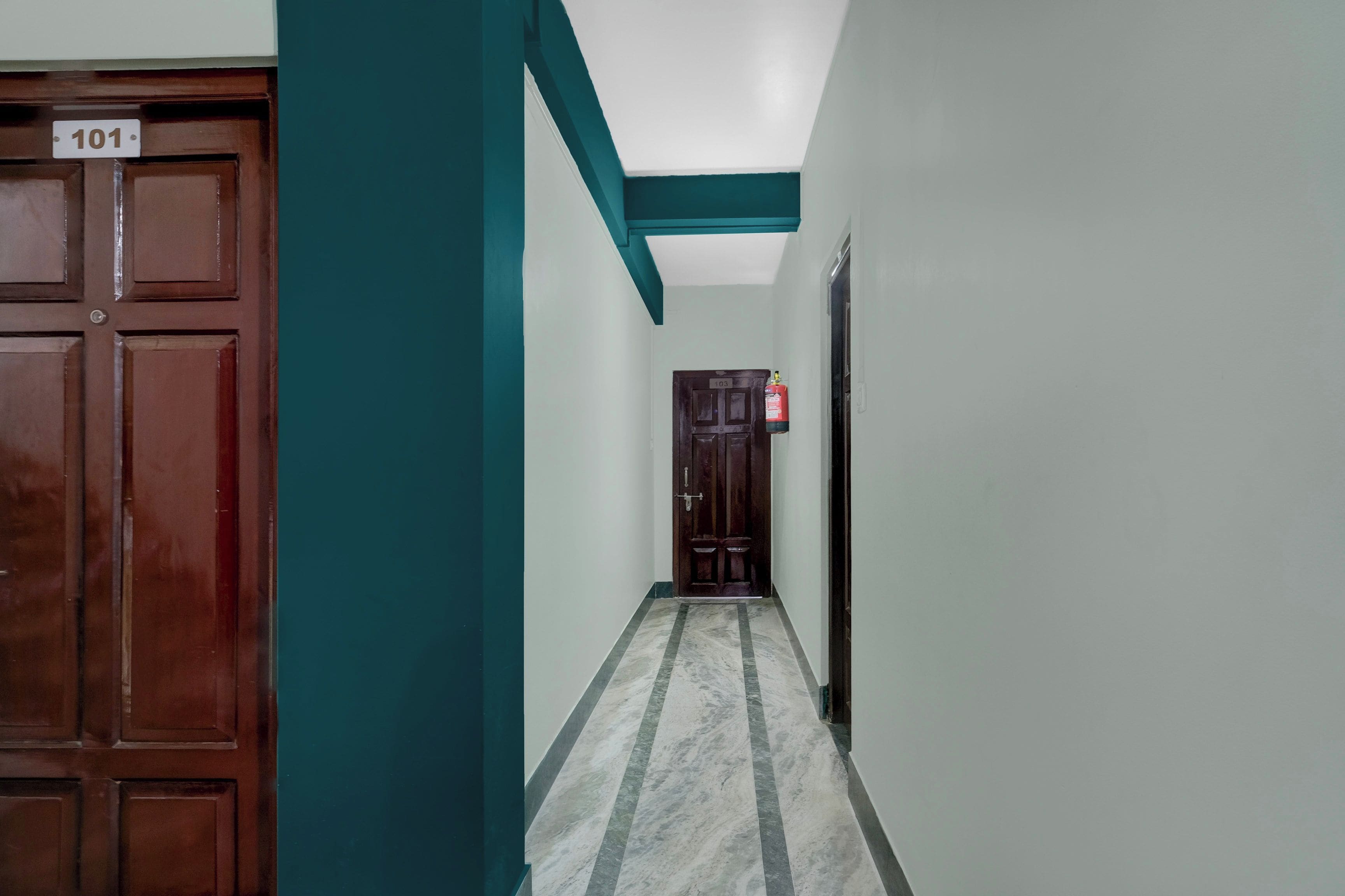A hallway with a wooden door labeled '101' and a fire extinguisher on the wall.