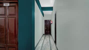 A hallway with a wooden door labeled '101' and a fire extinguisher on the wall.