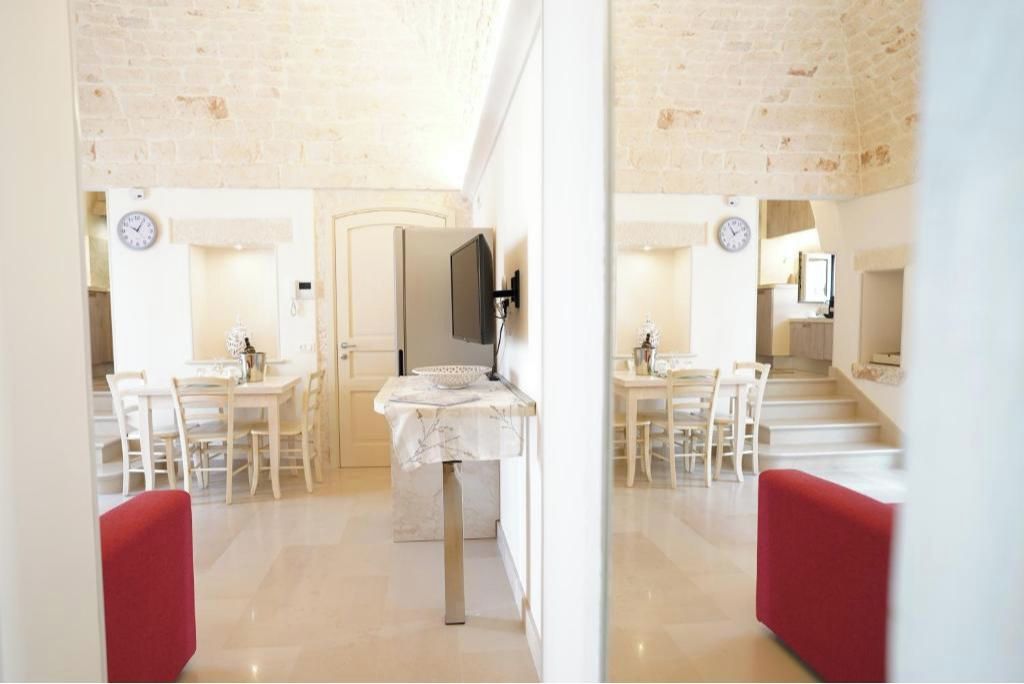 Un intérieur moderne comprenant un coin repas, une cuisine et un escalier menant à un autre niveau.
