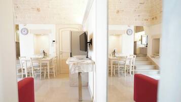 Un intérieur moderne comprenant un coin repas, une cuisine et un escalier menant à un autre niveau.