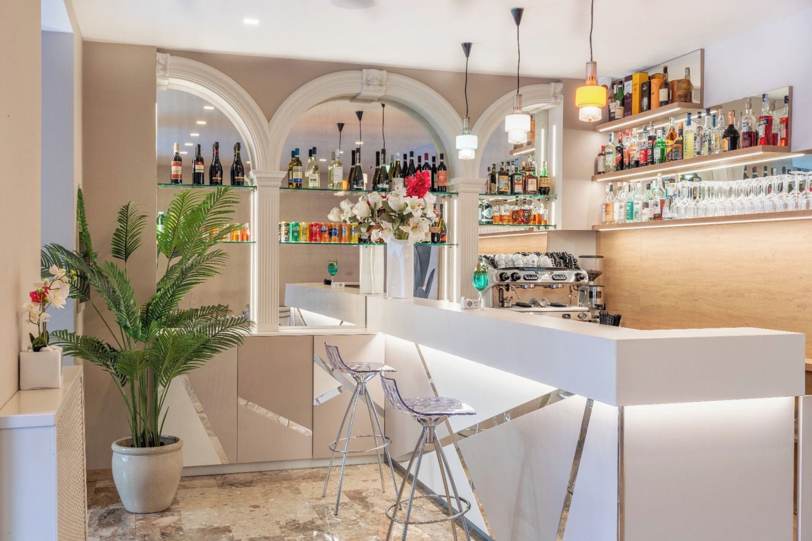 Een bar met een toonbank, zitplaatsen en een divers aanbod aan flessen en glazen.