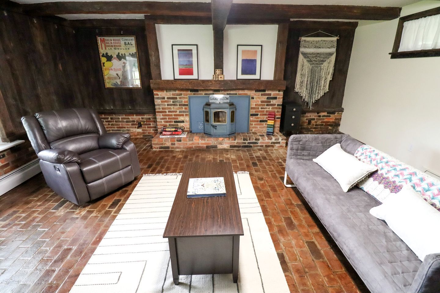 A cozy living room with a fireplace, leather recliner, sofa, and a coffee table.