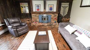 A cozy living room with a fireplace, leather recliner, sofa, and a coffee table.