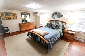 A bedroom with a bed, dresser, and a mirror.