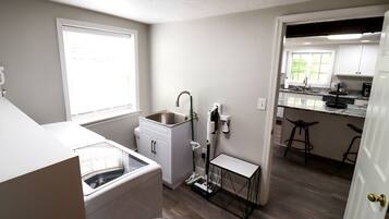 A compact kitchen with a built-in dishwasher, a small countertop, and a window providing natural light.