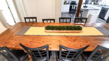 A dining area with a wooden table, six chairs, and a central decorative planter.