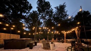 An outdoor patio area with string lights, seating, and planters.