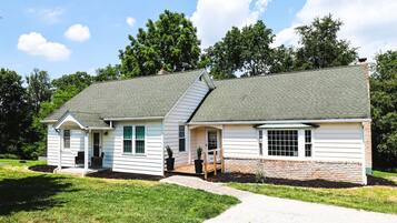 A two-story house with a front porch, a garage, and a brick foundation.