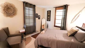 A bedroom with a bed, a desk, and a chair.