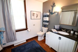 Ein Badezimmer mit Toilette, Waschbecken, Handtuchhalter und einem großen Spiegel.
