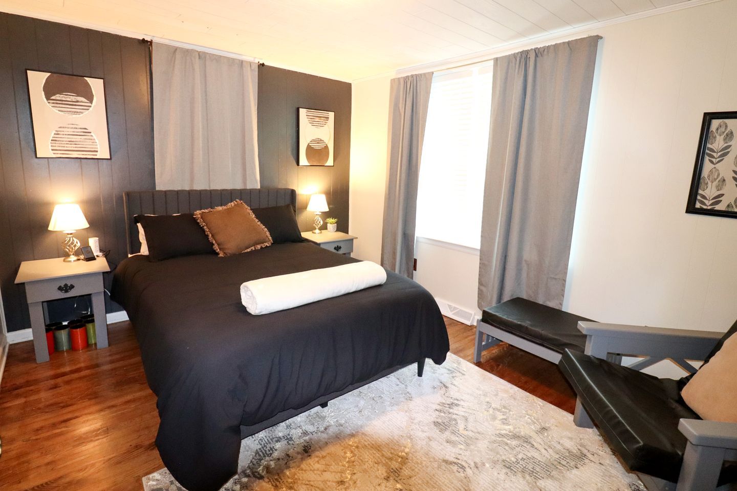 Una habitación de hotel con una cama grande, lámparas de noche, un escritorio y una silla.