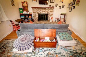 A living room with a fireplace, a sofa, a coffee table, and a rug.