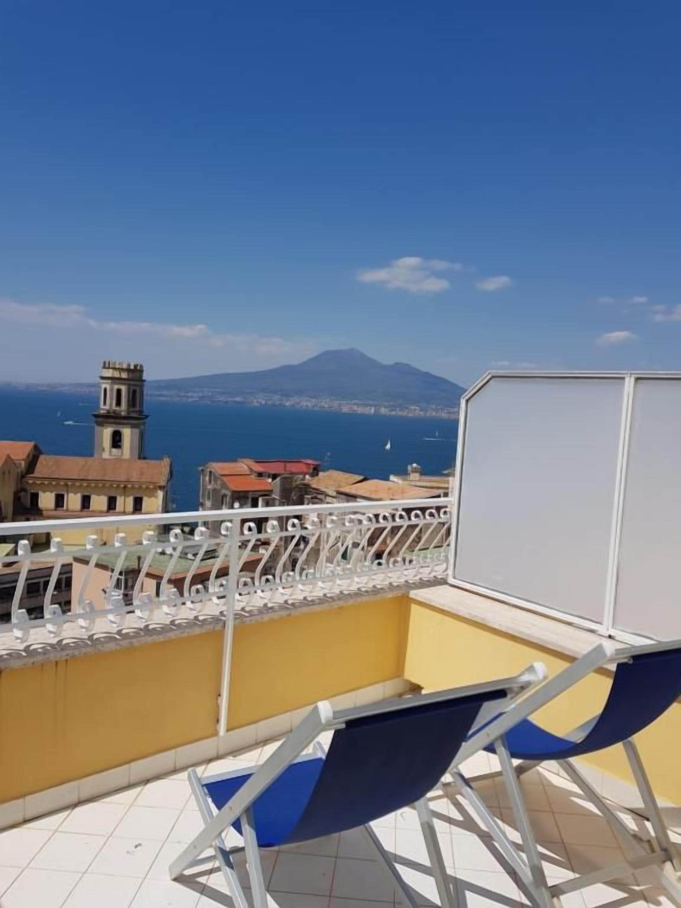 Un balcón con vistas despejadas al mar y una montaña en la distancia.