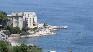 A coastal building with a beach and a pier.