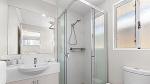 A modern bathroom with a glass-enclosed shower, a white sink, and a toilet. - Alkimos Coastal Escape (Alkimos)