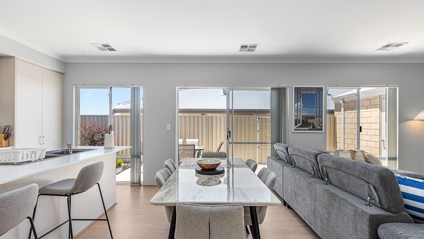 A modern kitchen with a dining area, a sofa, and a view of the outside. - Alkimos Coastal Escape (Alkimos)