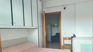 Une chambre à coucher avec un lit, un bureau et une armoire.