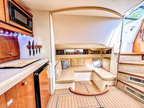 A compact kitchen with a microwave, knife block, and a built-in oven. - Waterfront Boat Stay & Resort Amenities (Key West)