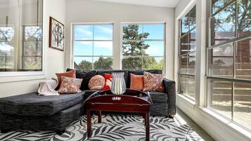 Een moderne woonkamer met een modulaire bank, een salontafel en grote ramen.