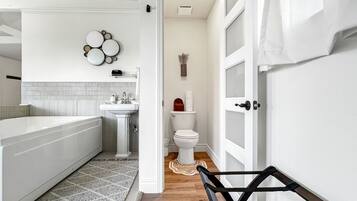 A modern bathroom with a bathtub, sink, and toilet.