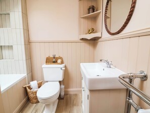 A bathroom with a toilet, sink, and a mirror. - Myrtle Cottage (Lynmouth)