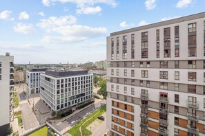 Ein mehrstöckiges Gebäude mit modernem architektonischen Design, das Glas- und Holzelemente in der Fassade vereint.