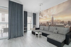 Ein modernes Wohnzimmer mit einer großen Couch, einem kleinen Tisch und einer Stadtlandschaftsmalerei an der Wand.
