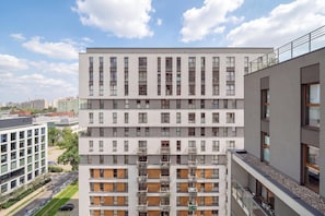A multi-story building with a modern architectural design, featuring a series of balconies and windows. - Apartament z Balkonem na 10 Pietrze w Lodzi by Noclegi Renters (Łódź)