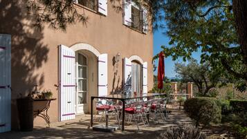 Un edificio con un patio amoblado, que cuenta con mesas y sillas al aire libre.