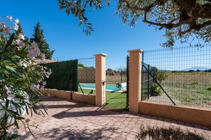 A gated property with a pool, a view of the landscape, and a clear sky.