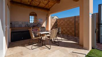 Eine Terrasse im Freien mit Tisch und Stühlen, einer Fliesenverkleidung und einer Holzbeschichtung.