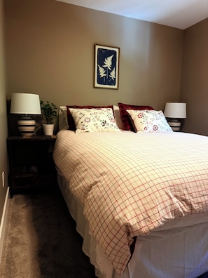 A bedroom with a bed, two nightstands, a potted plant, a framed artwork, and a carpeted floor. - LUX home on Golf Course-hot tub-sleeps 8 (Cle Elum)