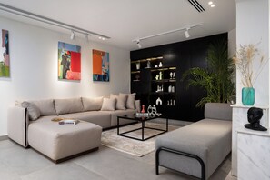 A modern living room with a sofa, a coffee table, and a bookshelf. - Amazing Deal at Elevens by Spacey #3 (cairo)