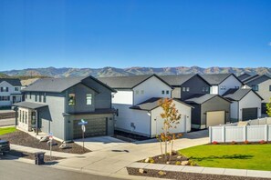 A row of modern single-family homes with attached garages, set against a backdrop of mountains. - Park City Views! Hot Tub, Game Room & EV Charger (Park City)