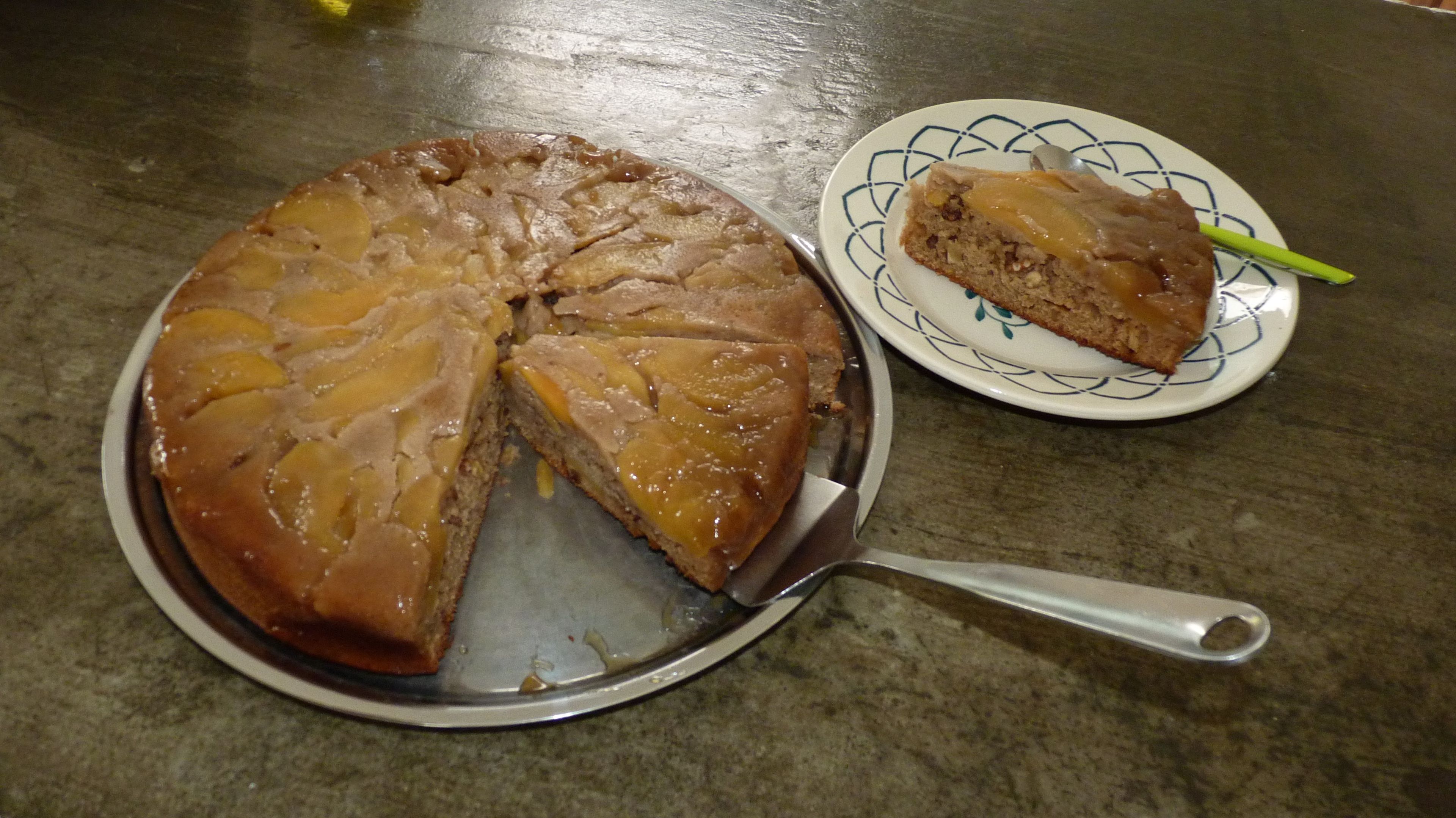 Un pastel redondo con una porción cortada, sobre una bandeja de metal.