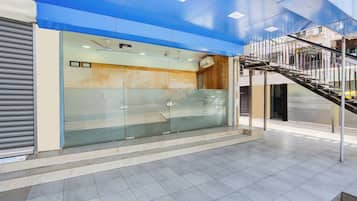 Un interior moderno con fachada de vidrio, una escalera y suelo de baldosas.