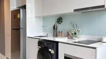 A modern kitchen with stainless steel appliances, white cabinetry, and a built-in oven.