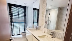 Une salle de bain moderne avec un grand miroir, un lavabo et des toilettes.