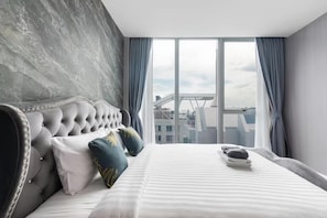 A modern bedroom with a tufted headboard, a large window with curtains, and a city view. - Hyde Sukhumvit 11 at Nana BTS Station (Krung Thep Maha Nakhon)