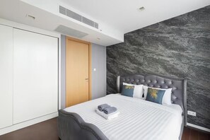 A modern bedroom with a bed, a wardrobe, and a marble wall. - Hyde Sukhumvit 11 at Nana BTS Station (Krung Thep Maha Nakhon)