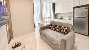 Un salon moderne avec un canapé, une petite table et un téléviseur.