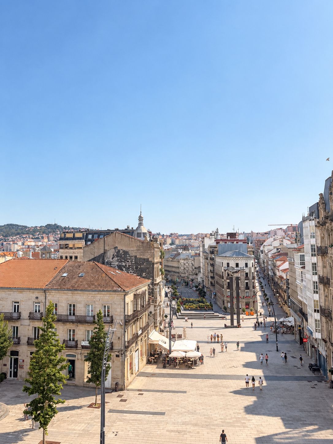 A wide, open square with historic buildings, a prominent tower, and a clear sky.