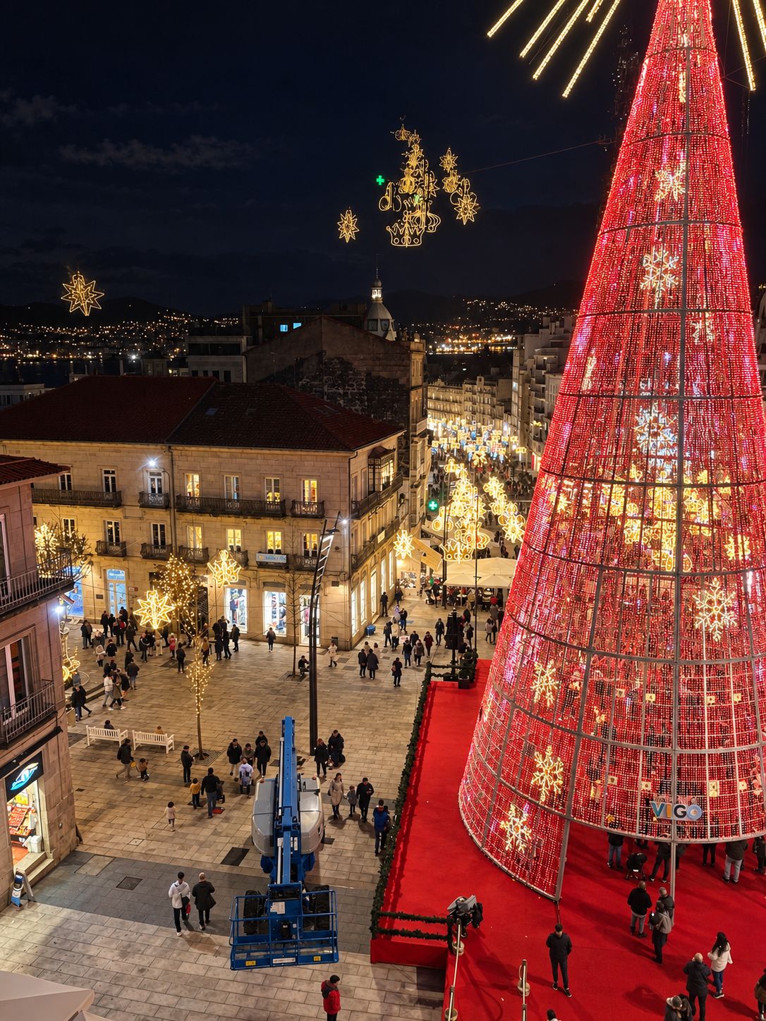 Una plaza con un gran árbol de Navidad iluminado y una alfombra roja.