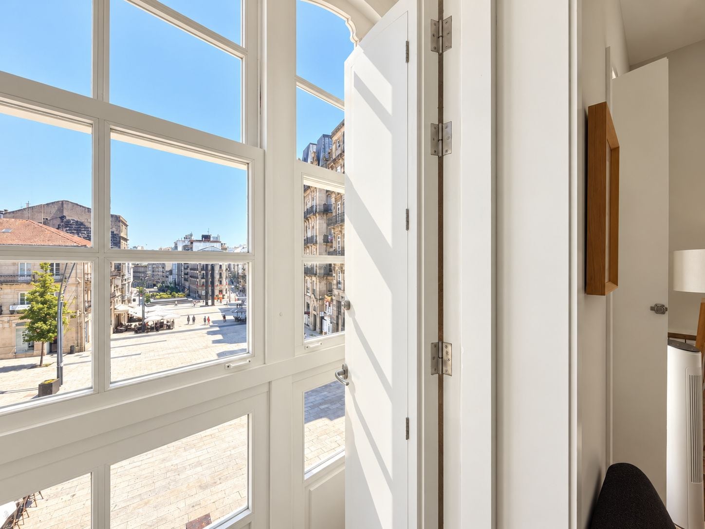 A room with large windows, a door, and a view of a city street.